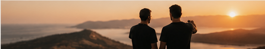 Two crew members watching the sunset on a hilltop