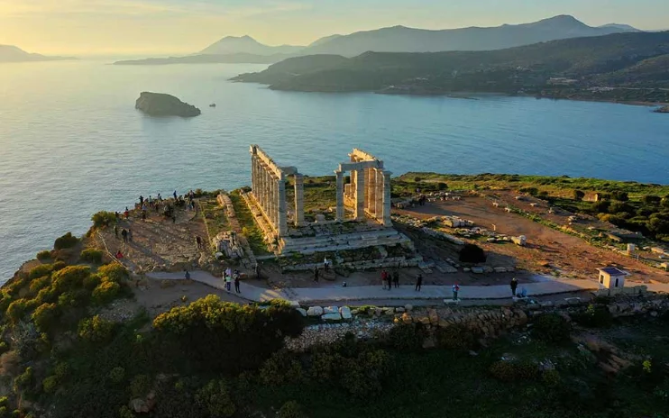 Ancient temple ruins on a coastal headland at sunset