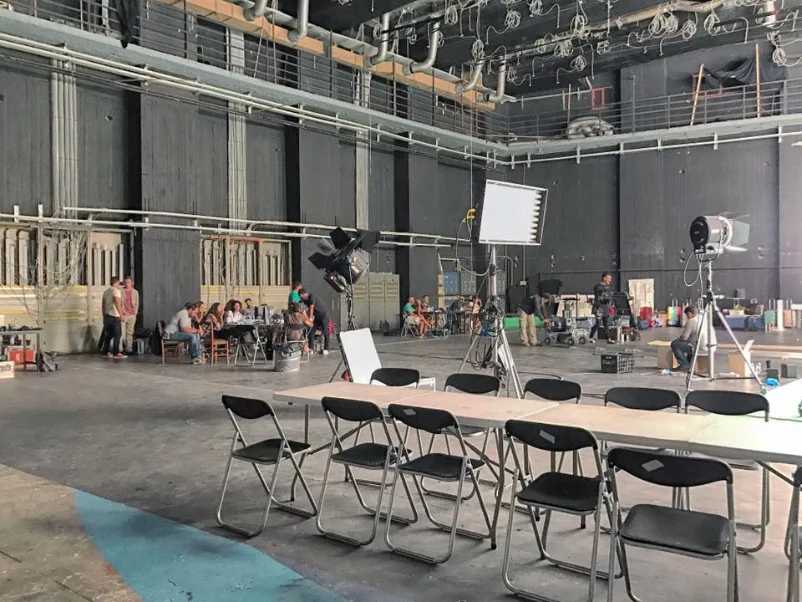 Film crew with lighting equipment set up on a soundstage floor